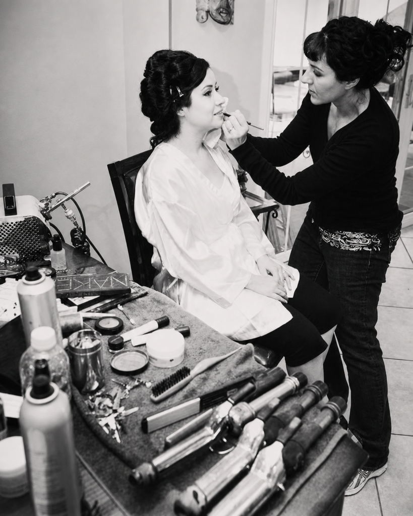 I’m applying makeup to a seated client, with my brushes and products nearby.