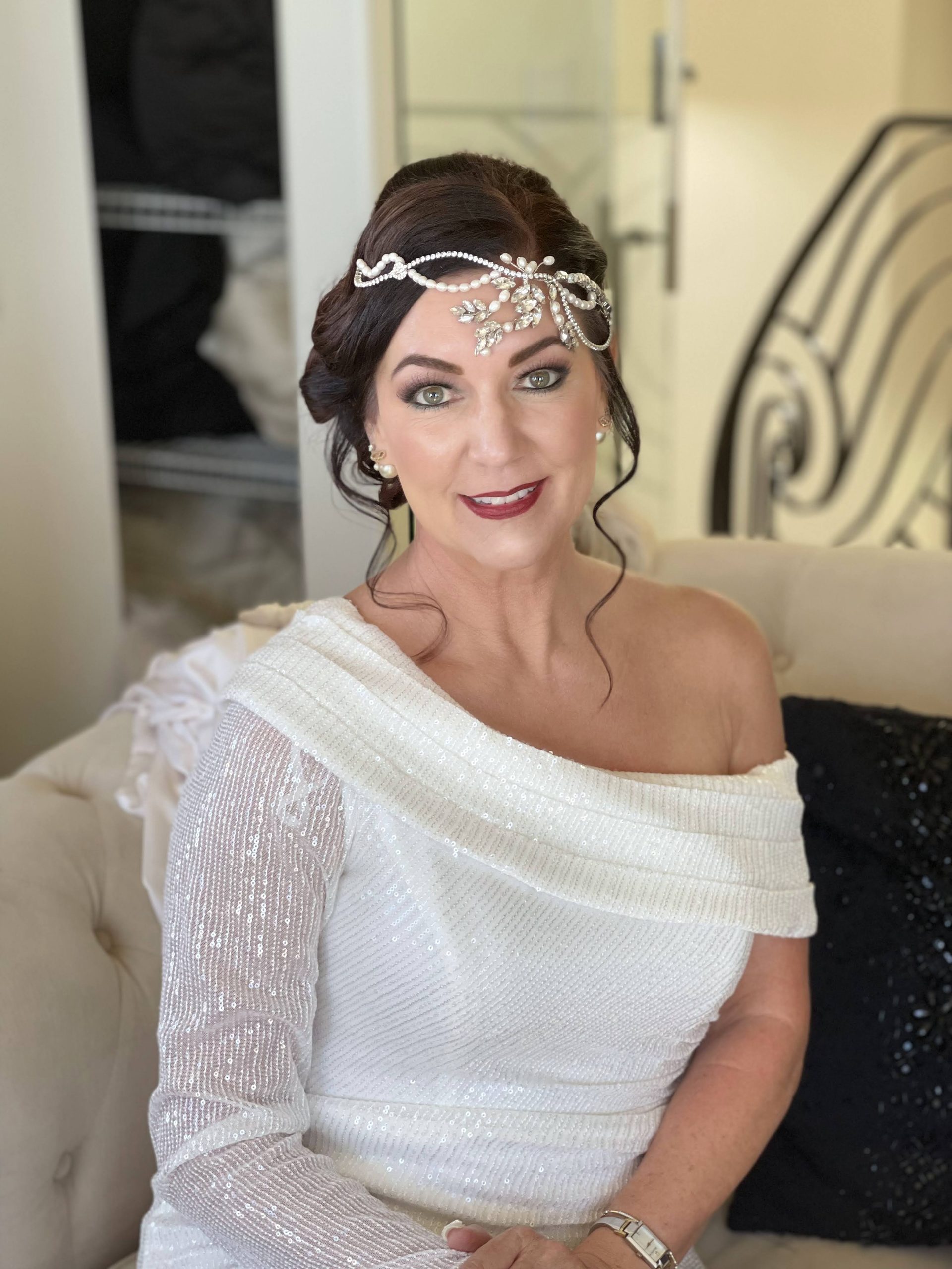 My client with an updo, pearl headpiece, defined eyes and deep red lipstick.