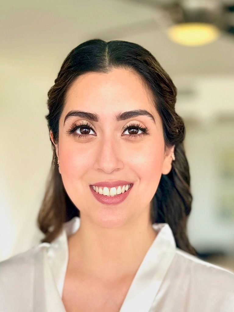 My natural glam makeup with defined brows and lashes on a smiling client.