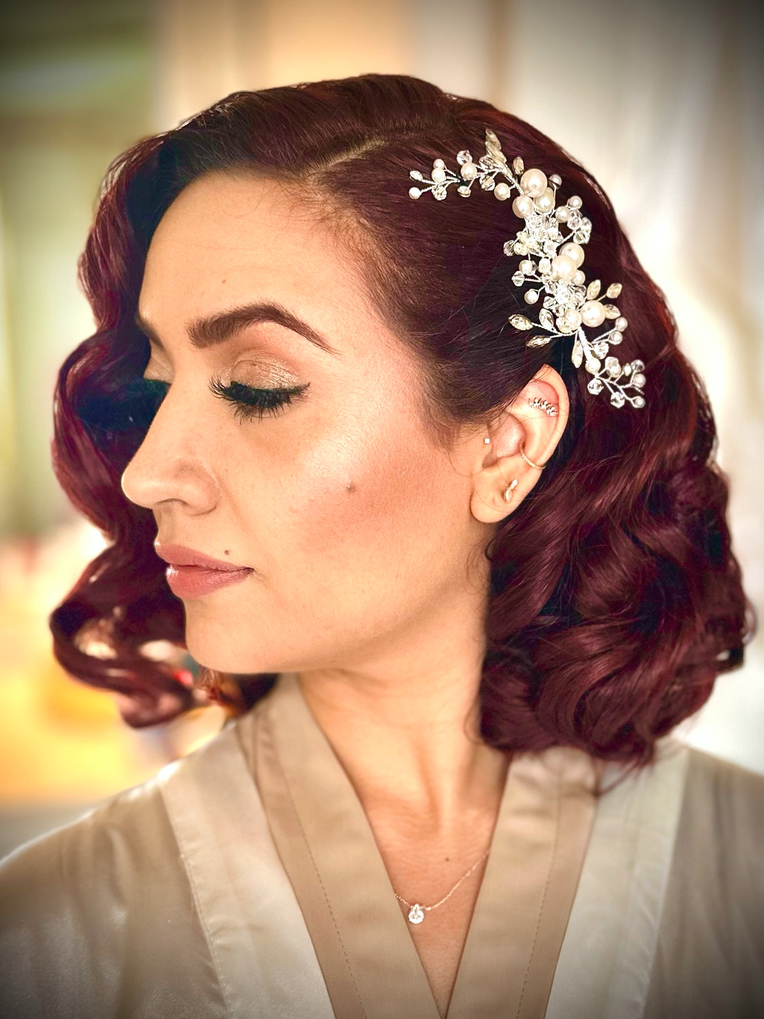 My shimmering eye makeup and vintage auburn waves with a pearl hair comb, in profile.