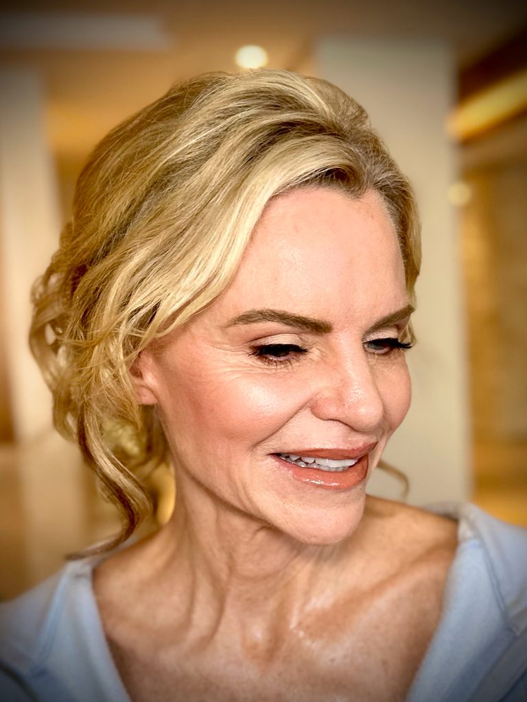 My radiant makeup and soft blonde updo on a smiling mature client.