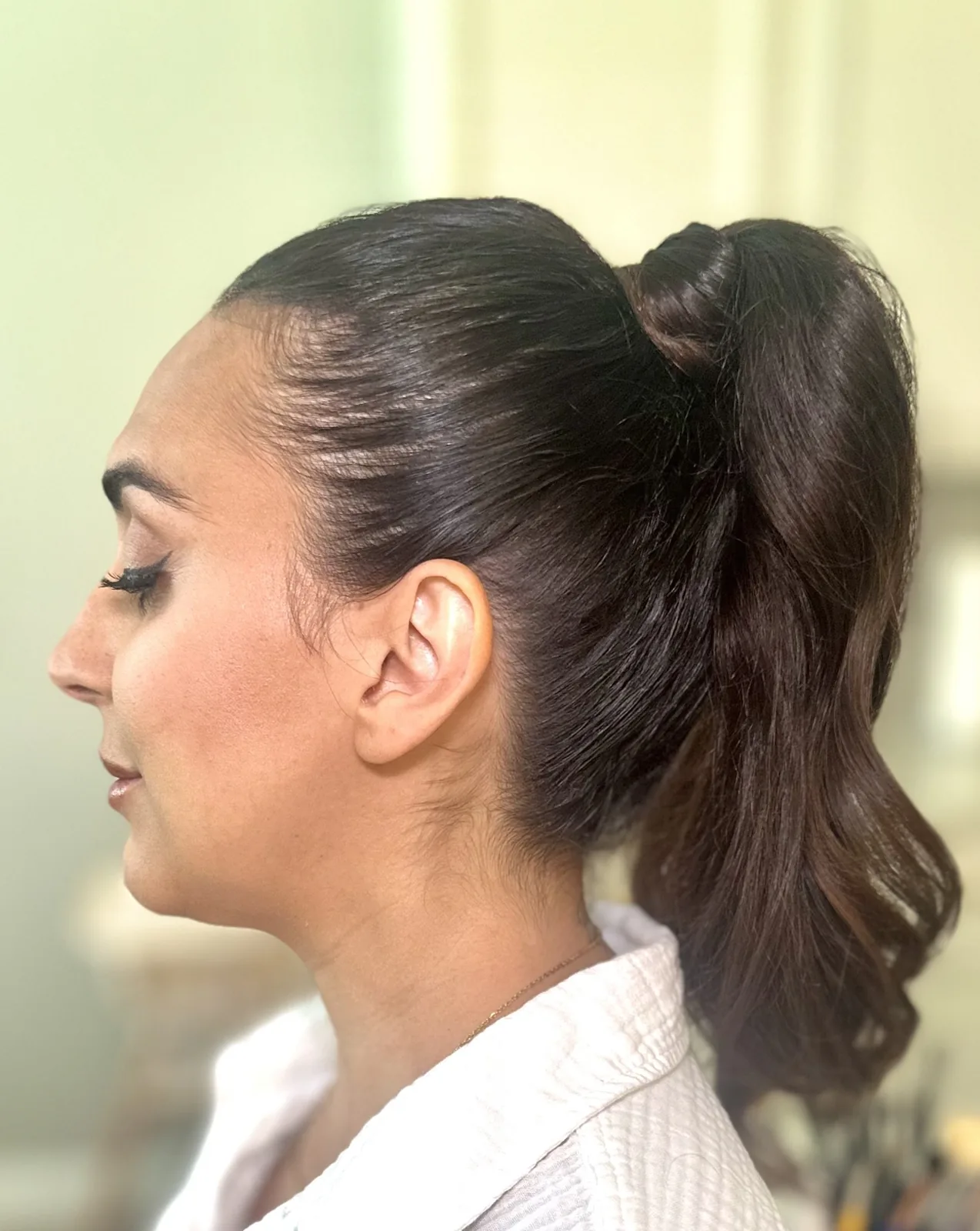 My glowing makeup and sleek high ponytail on Siona, viewed from the side.