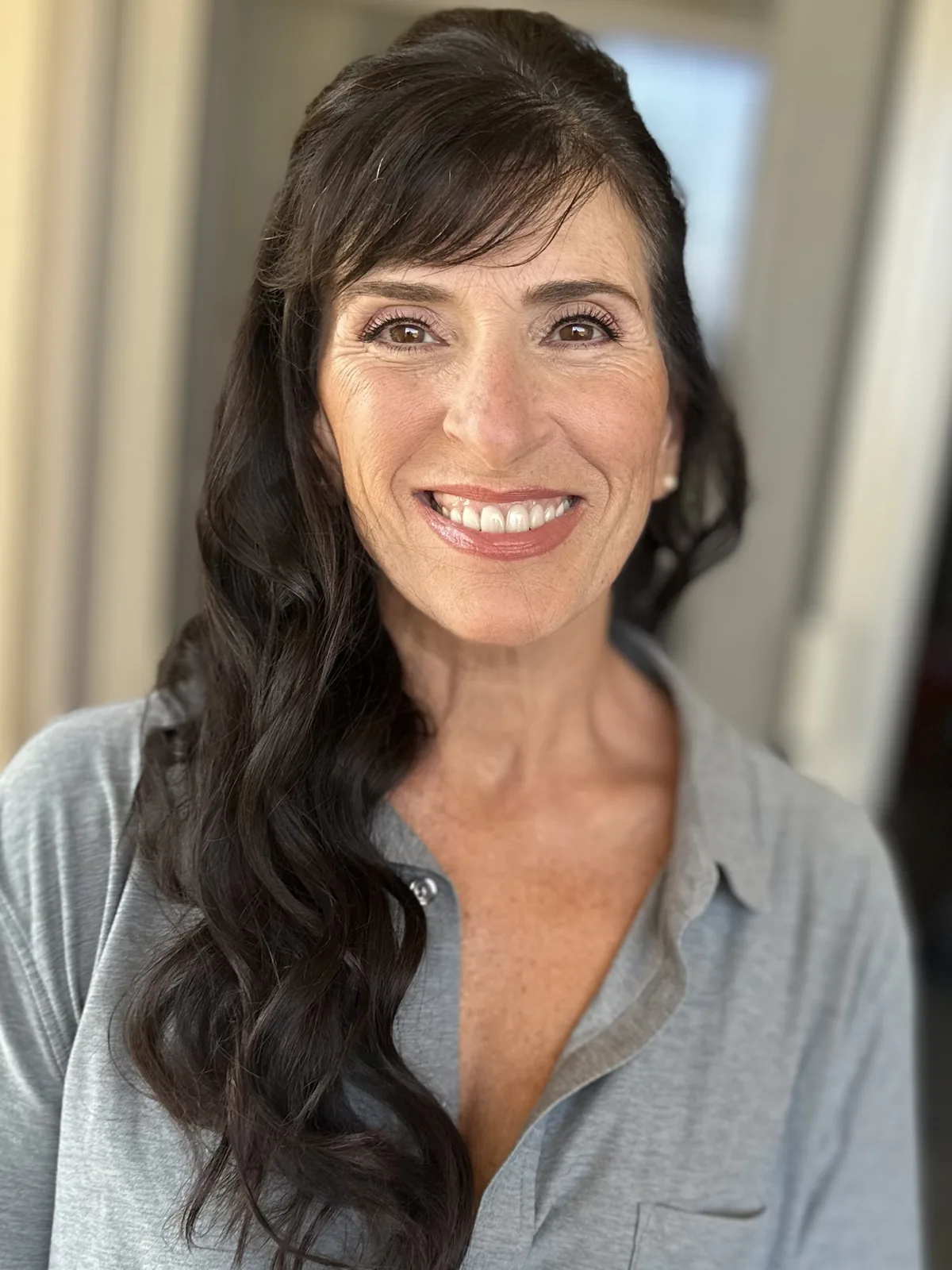 My natural makeup and half-up waves on a smiling client in Newport Beach.