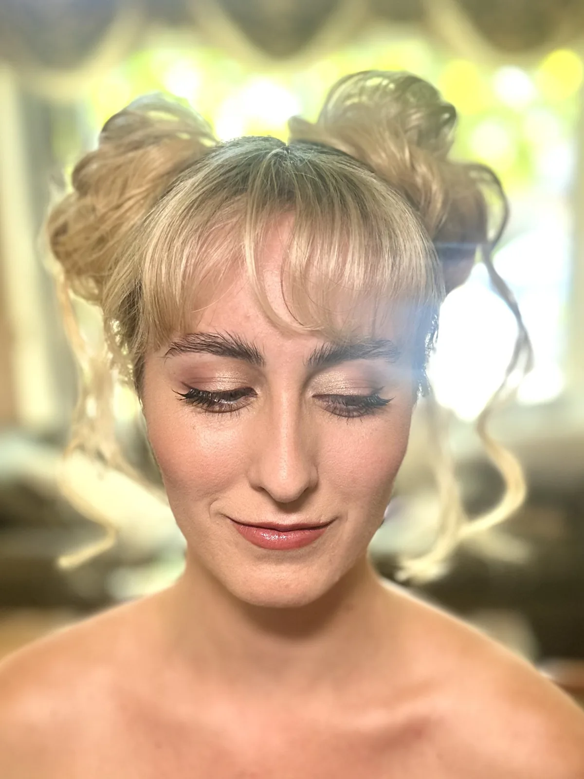 My warm eye makeup and space buns on Sabrina with her eyes closed.
