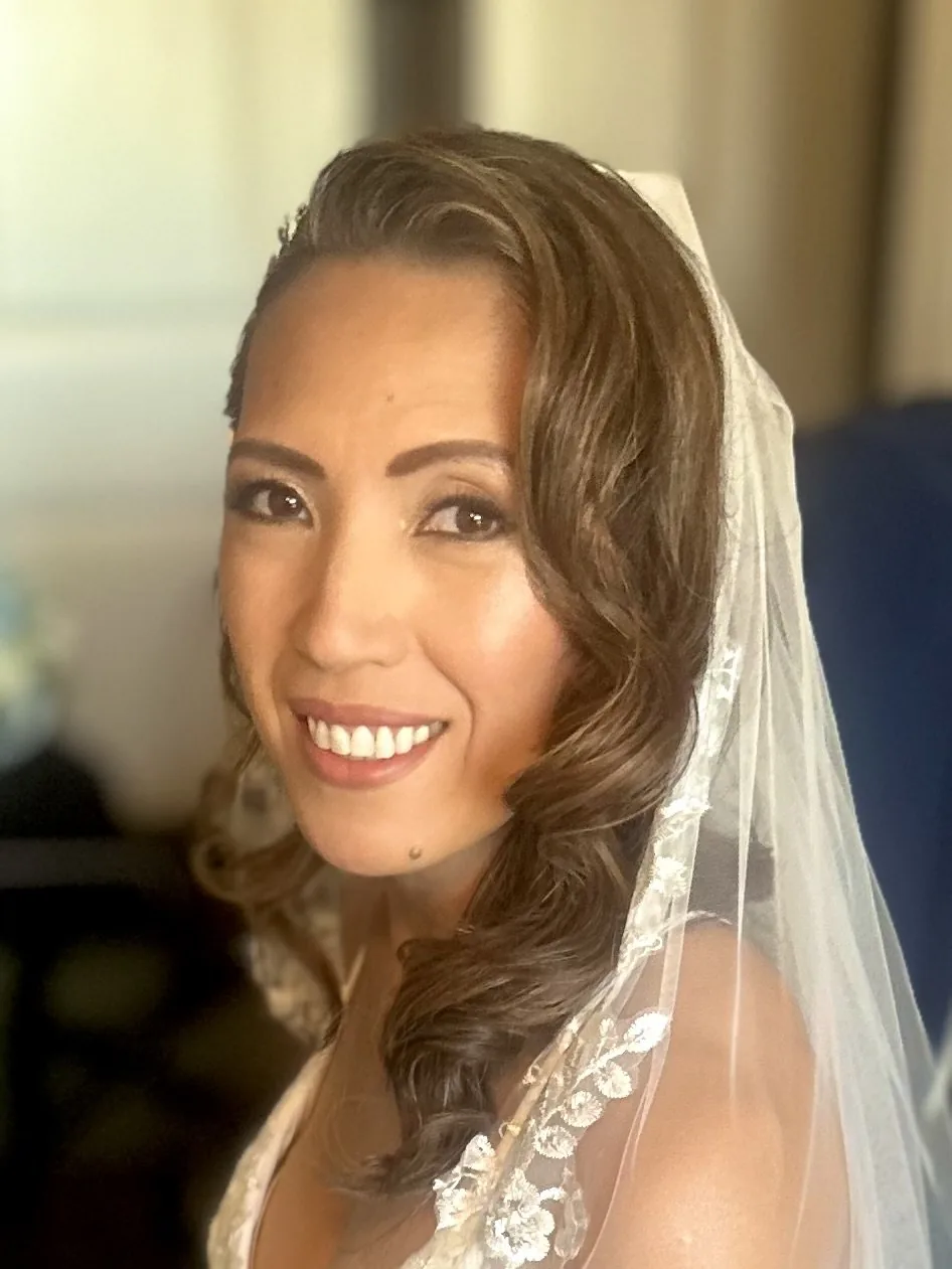 My finished bridal makeup and vintage waves on Macky, smiling beneath her veil.