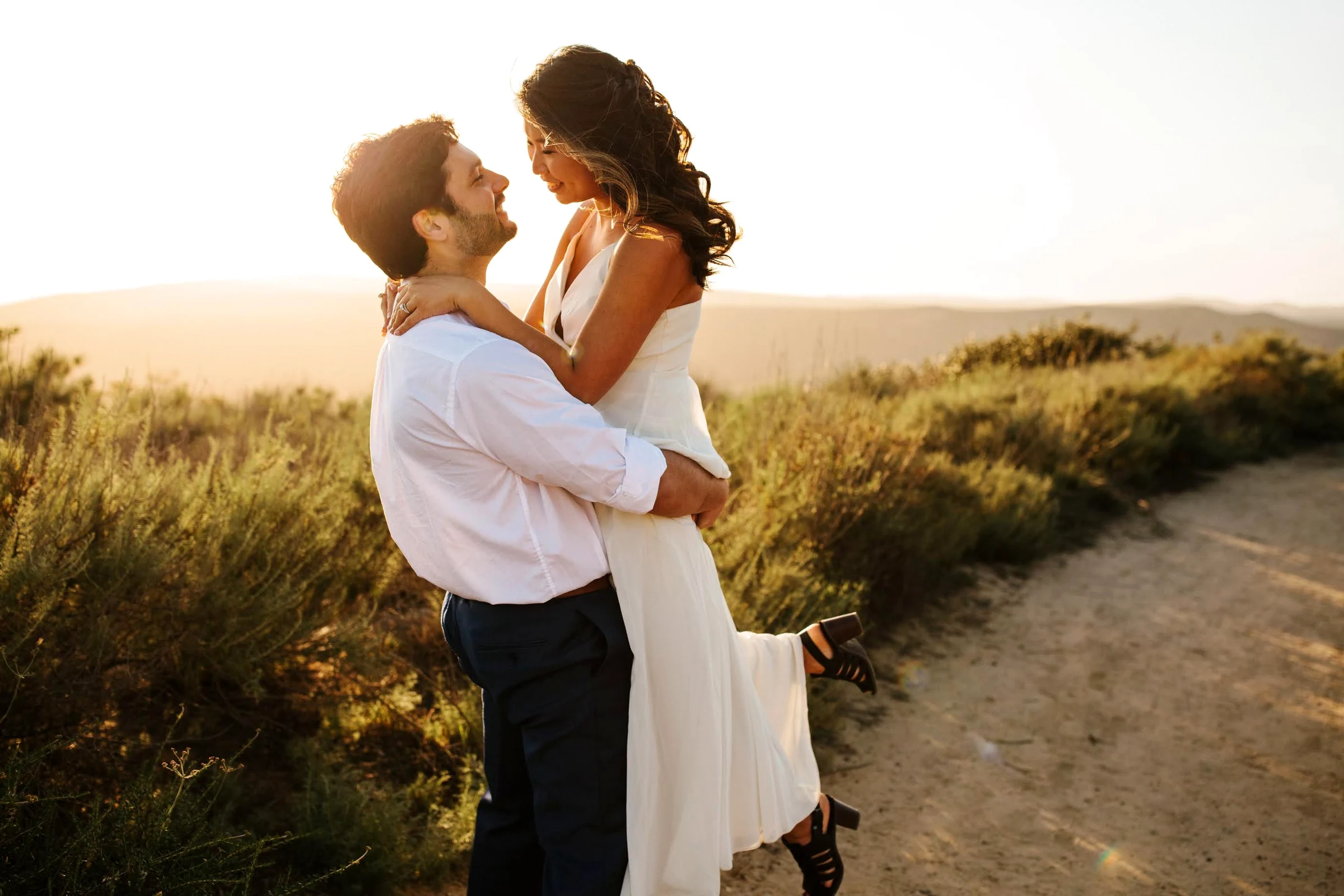 My finished bridal makeup and hair on a bride with her partner outdoors.